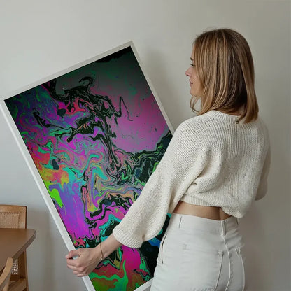 Woman holding a large "Slick 1 Print" with vibrant oil slick abstract art on thick archival paper.
