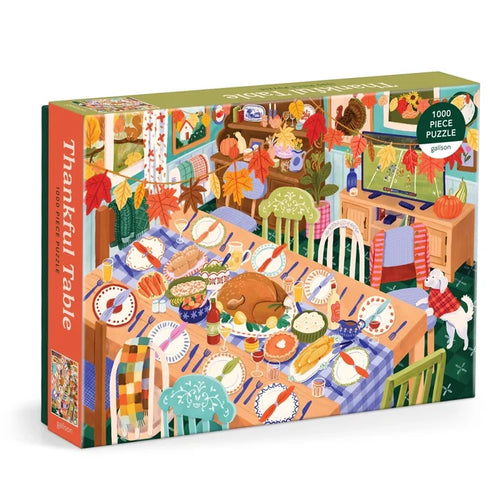 The "Thankful Table" 1,000 Piece Jigsaw Puzzle by Galison showcases an illustrated Thanksgiving scene with a golden roast turkey, lavish holiday dishes, festive autumn décor, and a cheerful dog in a vibrant dining room.