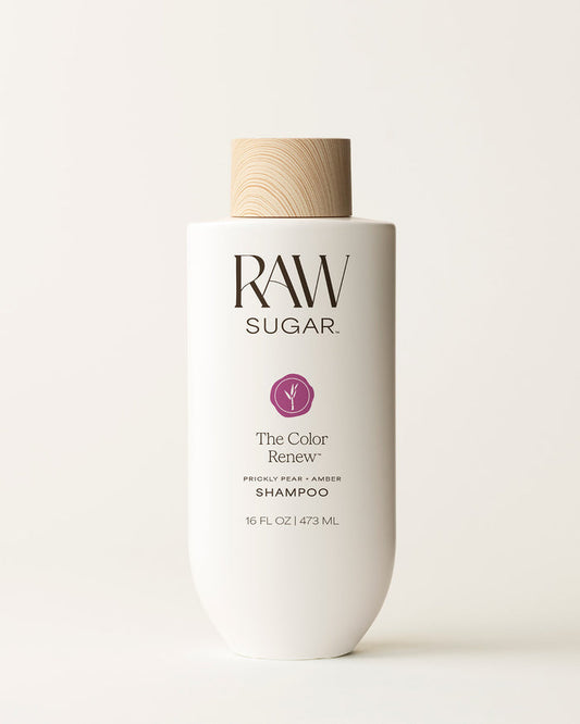 Bottle of Raw Sugar Color Renew Shampoo on a cream background, designed to help color-treated hair with clean ingredients.