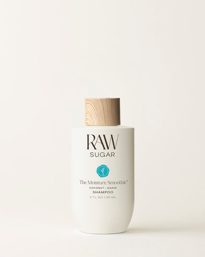 Travel Bottle of Raw Sugar Moisturizing Shampoo on a cream background, designed to help moisturize hair with clean ingredients.
