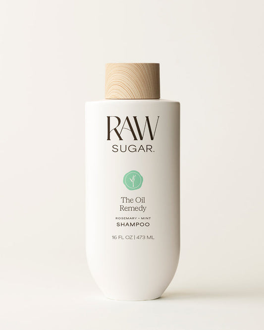 Bottle of Raw Sugar Oil Remedy Shampoo on a cream background, designed to help balance hair with clean ingredients.