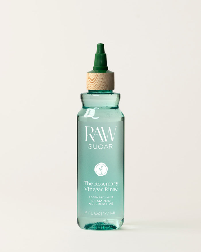 Bottle of Raw Sugar Rosemary  Vinegar Shampoo on a cream background, designed to help refresh hair with clean ingredients.
