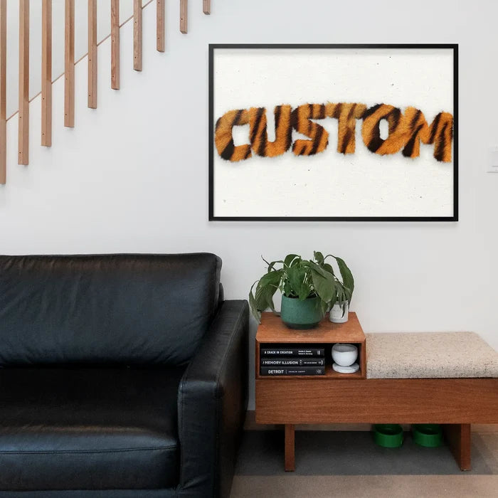 Framed "CUSTOM" print in realistic tiger stripe fur style, on a white background, above a modern living room setup.