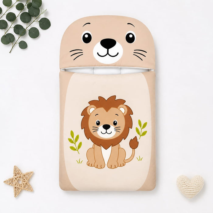 A children's sleep sack or blanket featuring a cute cartoon lion on the front and a matching lion-face hood, shown in a styled flat-lay with eucalyptus leaves, a star, and a small heart on a white background.